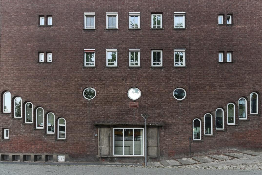 Building façade where window shapes create the illusion of a face due to pareidolia.