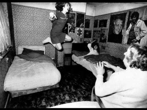 Black and white photo of a girl levitating above her bed during an alleged poltergeist incident.