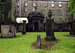Historic graveyard courtyard connected to paranormal folklore and reports of haunted houses.